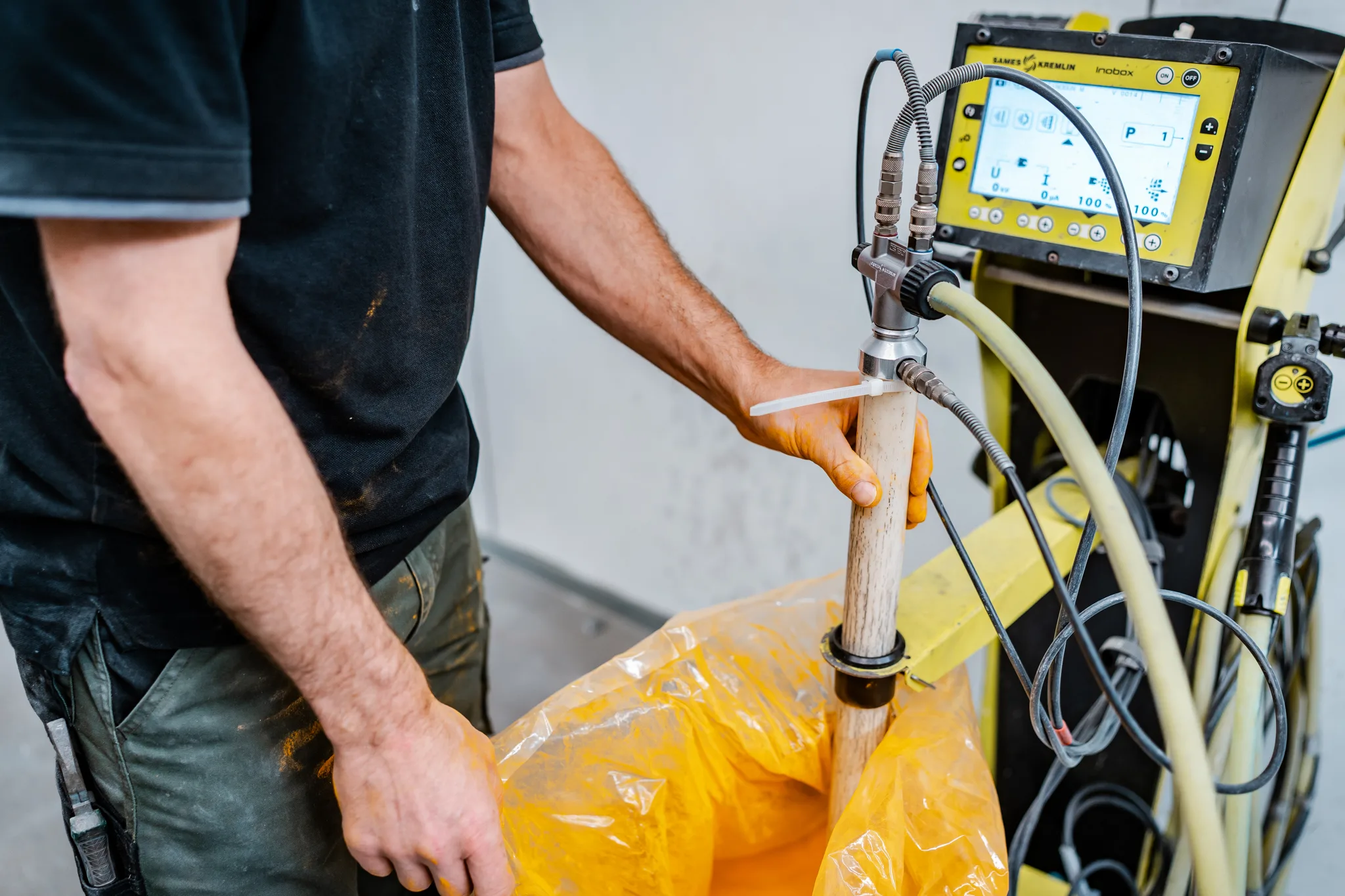 Medewerker bedient de digitale besturingsunit van de poedercoatinstallatie bij BMS Coating