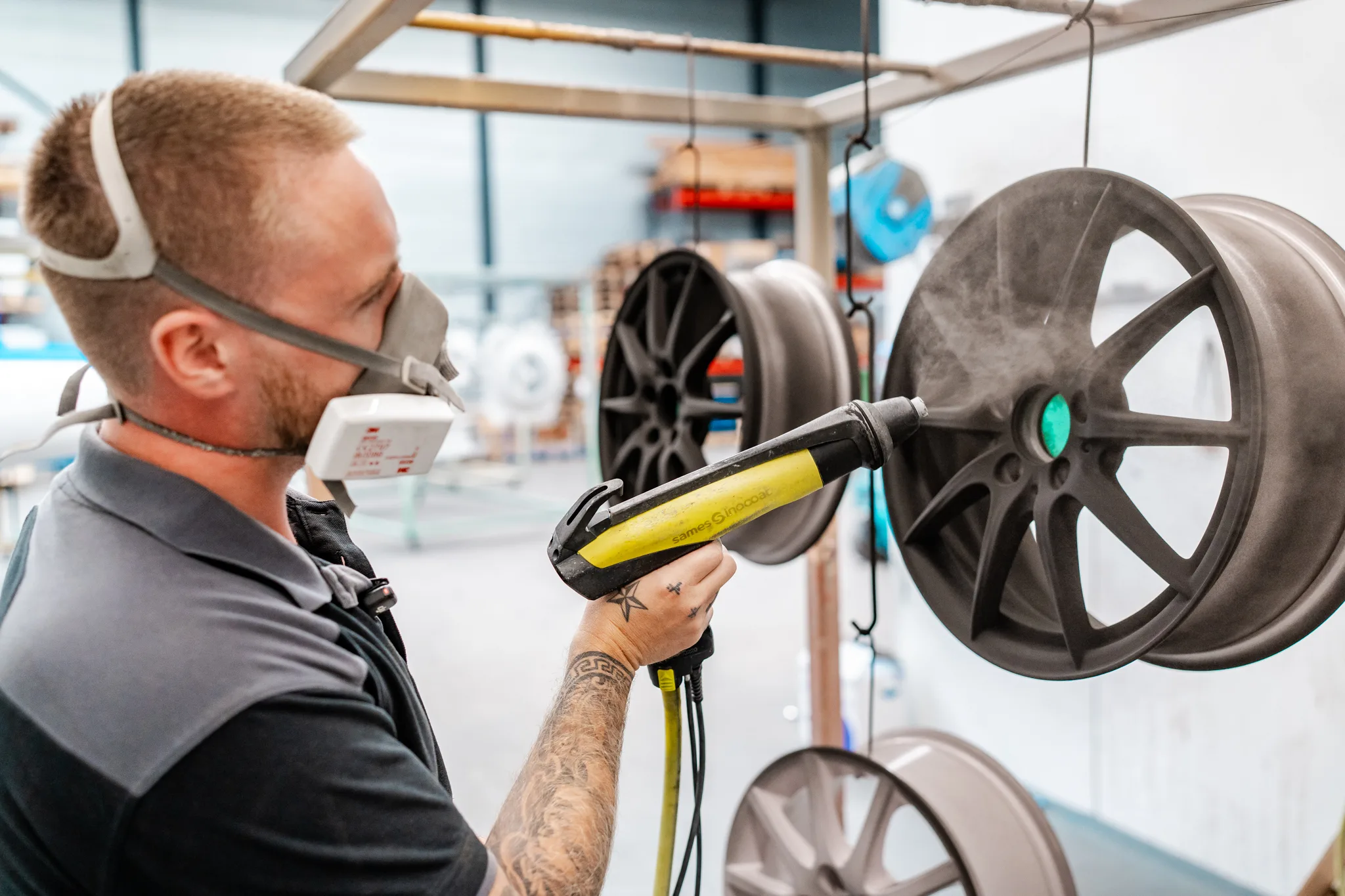 Medewerker van BMS Coating poedercoat autosportwielvelgen in donkergrijze kleur